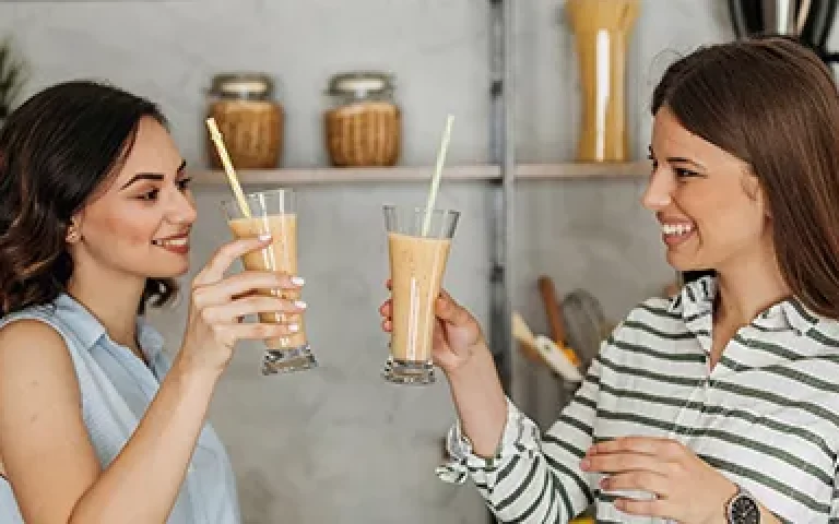 Two women drinking Herbalife meal replacement shake