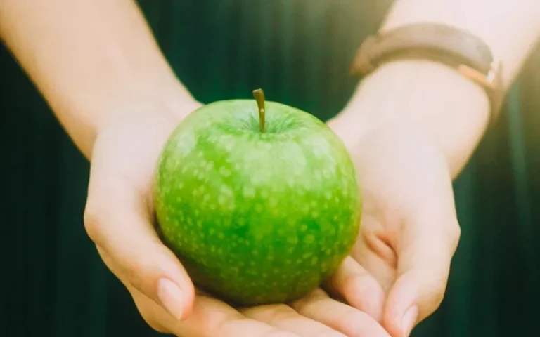 person holding green apple